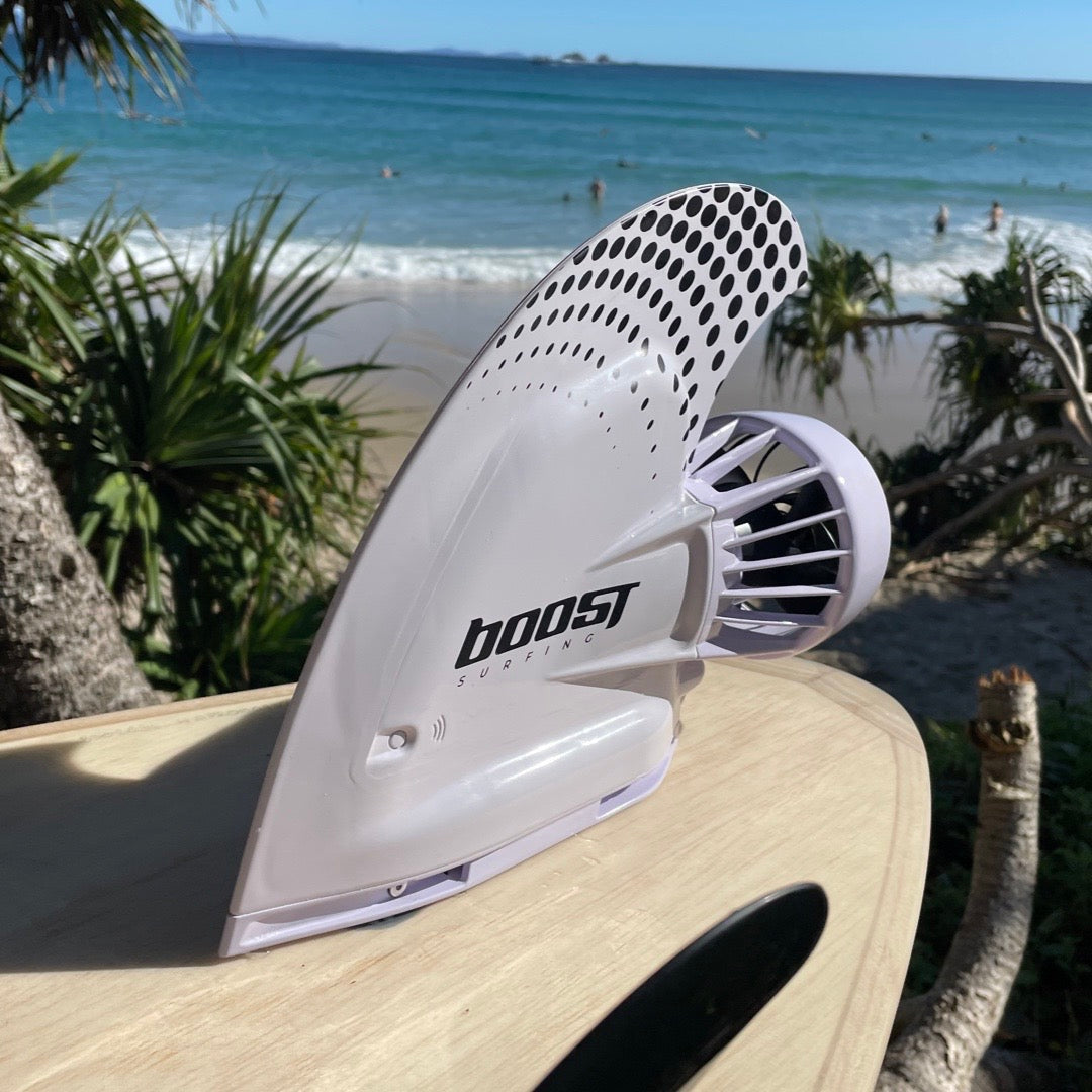 Boost Surfing Fin on a wooden surfboard in front of an Australian beach